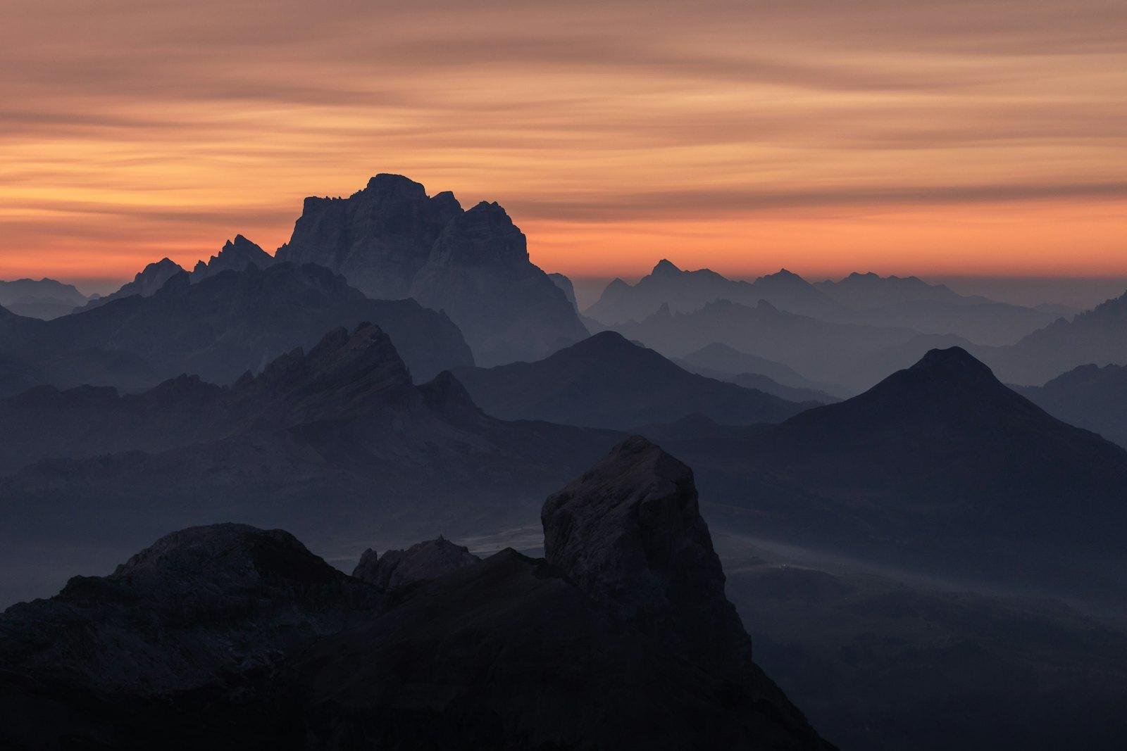 Mountain peaks silhouetted at sunrise in the Dolomites